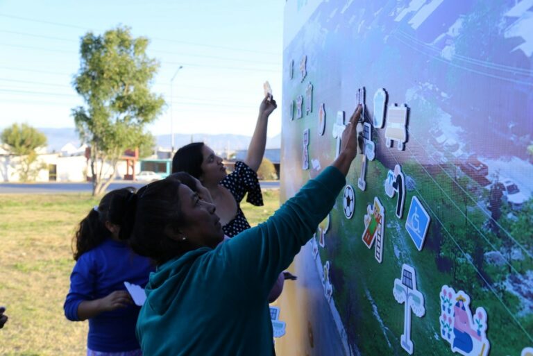 Women who participate in the workshop place their desired park elements on the board.